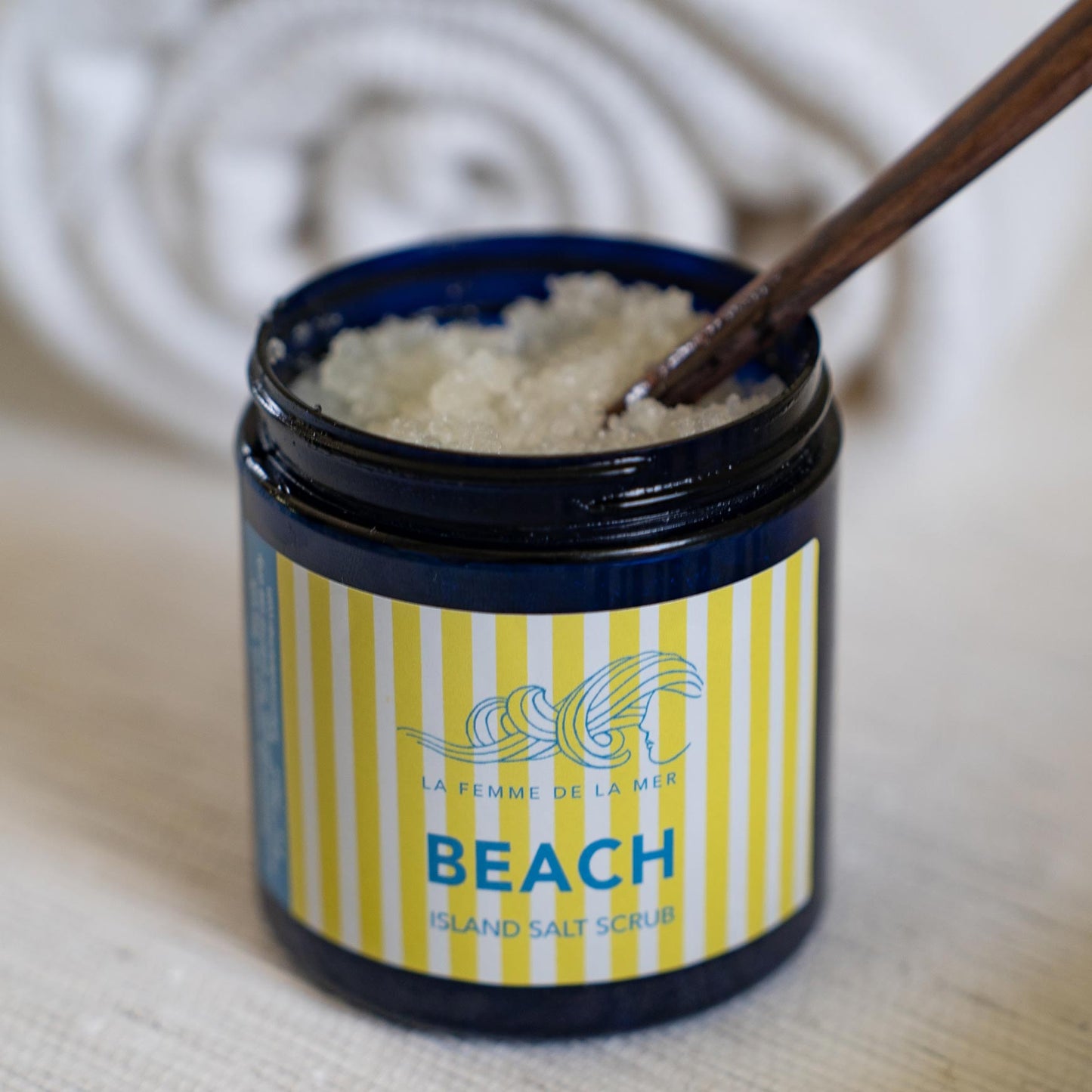 beach scent salt scrub opened container front white and yellow stripes label